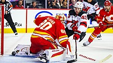 Branká� Dan Vlada� z Calgary Flames zasahuje proti zakon�ení Lukea Hughese z...