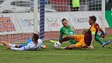 Ostravský Erik Prekop zkou�í zakon�it p�ed branká�em Matú�em Hru�kou a Janem...