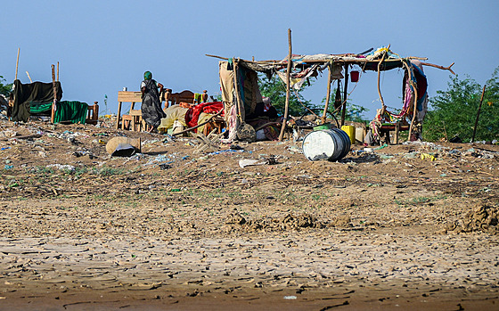 Súdánská �ena krá�í poblí� provizorního p�íst�e�ku v Tokaru. (3. �íjna 2024)