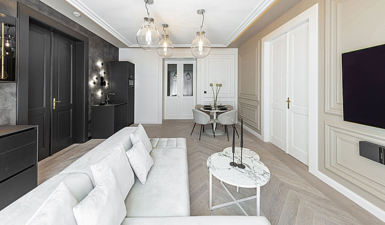 V obývacím pokoji se kuchy�ská linka v hlubokém �erném matu �ztrácí� na pozadí...