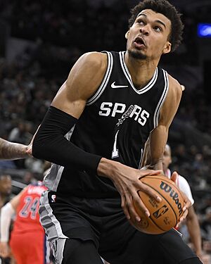 Victor Wembanyama (vpravo) ze San Antonia br�n�n� Kylem Kuzmou z Washingtonu.