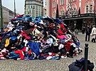 Hromada textilu v centru Prahy. Darovan kusy obleen si fot turist