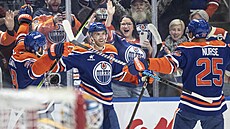 Connor McDavid (vlevo) z Edmontonu slaví tisící bod v NHl. S gratulací sp�chá...