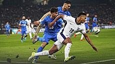 Anglický úto�ník Ollie Watkins uhání za mí�em, následují ho �ekové Lazaros Rota...