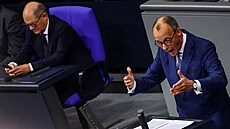 éf CDU Friedrich Merz ení v Bundestagu. V pozadí kanclé Olaf Scholz (SPD)...
