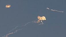 Stopy po raketách a kouř po explozích raket jsou vidět na obloze nad Kyjevem...