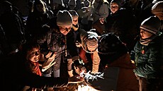 Lidé zapalují sví�ky u lavi�ky Václava Havla v Gahurov� prospektu ve Zlín�....