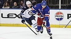Filip Chytil (vpravo) z New York Rangers úto�í v zápase s Winnipegem, stíhá ho...