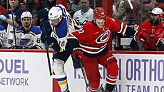 Radek Faksa (12) ze St. Louis Blues sráí Jesperiho Kotkaniemiho z Carolina...