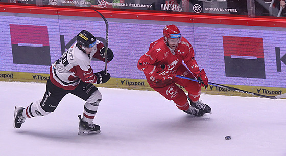 Ond�ej Kova��ík z T�ince sp�chá za pukem p�ed Davidem Vitouchem ze Sparty.