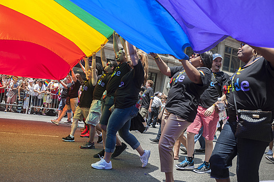 Zam�stnanci spole�nosti Walmart nesou ob�í duhovou vlajku na ka�doro�ním...