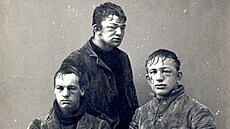 Vlevo sedící Darwin R. James, tém�� z profilu zachycený John P. Poe a mladík s...