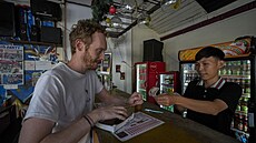 Zahrani�ní turista si kupuje kávu v baru hostelu Nana Backpack v laoském Vang...