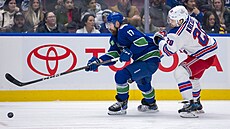 Filip Hronek (17) z Vancouver Canucks u puku v zápase s New York Rangers, stíhá...