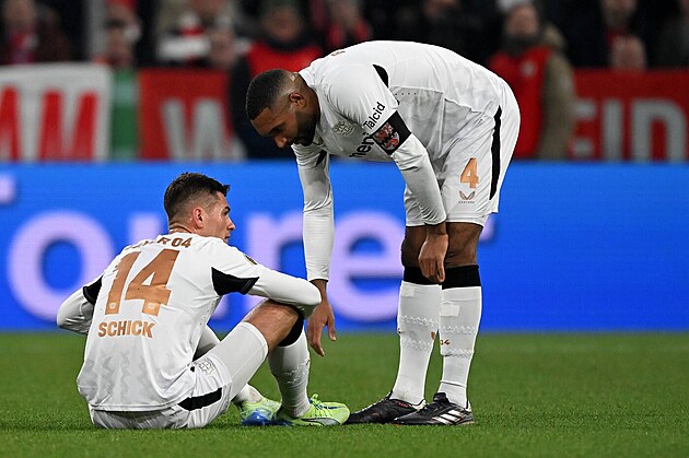Zran�n� Patrik Schick. Skl�n� se nad n�m kapit�n Leverkusenu Jonathan Tah.