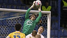 Teplický branká� Richard Ludha chytá mí� p�ed Michalem Hlavatým z Liberce.