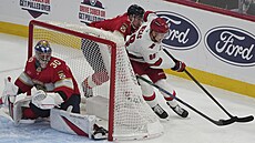 Útoník Caroliny Martin Neas (vpravo) se snaí udret puk za brankou Floridy.