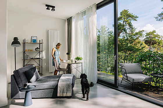 Posuvné okno v obývacím pokoji je spojené s terasou a rámuje úchvatný obraz,...