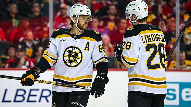 David Pastr��k a Elias Lindholm z Bostonu se domlouvaj� p�i utk�n� proti Calgary.
