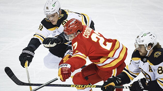 Dvojice z Bostonu Nikita Zadorov (vlevo) a David Pastr��k se sna�� zastavit Matthewa Coronata z Calgary.