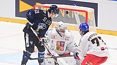 �eský branká� Josef Ko�ená� hledá puk p�es finského úto�níka Patrika Puistolu...