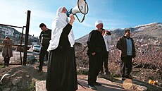Drúzská �ena na izraelské stran� hranice volá megafonem zprávy svým p�íbuzným...