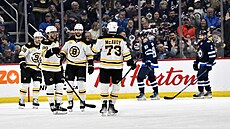 Úto�ník Bostonu David Pastr�ák (druhý zleva) slaví s Pavlem Zachou (t�etí...