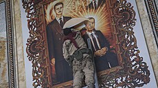 Syrský opozi�ní povstalec v Aleppu trhá obraz prezidenta Ba�ára Asada a jeho...