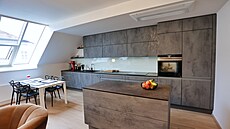 Moderní kuchy� s ostr�vkem a tmavými povrchy je stylov� za�ízená, s d�razem na...