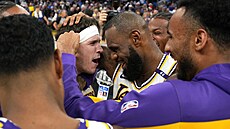Austin Reaves (s �elenkou) a p�ijímá gratulace spoluhrá�� z LA Lakers. Práv� ho...