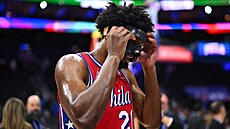 Joel Embiid z Philadelphia 76ers si upravuje ochrannou masku bhem utkání s...