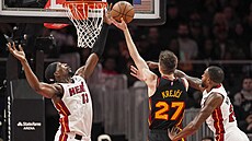 Vít Krej�í se sna�í zakon�it nájezd p�es blokující ruku Bama Adebaya.