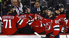 Jack Hughes (86) slaví se spoluhrá�i z New Jersey Devils gól.
