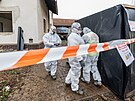 Technici v ochrannch oblecch demontuj azbestovou krytinu ped demolic dom,...