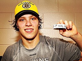 Hokejový úto�ník David Pastr�ák s pukem po prvním gólu v NHL (10. ledna 2015)