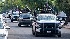 Vojáci Národní gardy hlídkují na ulici po st�elb�, která zasáhla budovu novin...