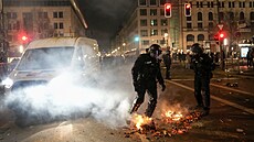 Policie hasí oheň vzniklý používáním petard během  novoročních oslav v Berlíně....