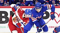 �eský úto�ník Petr Sikora v souboji s Ameri�any o puk v semifinále MS junior�.