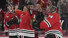 Seth Jones (4) a Petr Mrázek (34) slaví výhru Chicago Blackhawks.