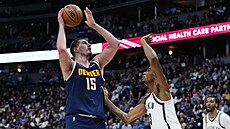 Nikola Joki� z Denveru zakon�uje, brání ho Nic Claxton z Brooklynu.