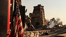 Hasi�i hasí ho�ící uhlíky u zni�ené budovy William D. Davies Memorial Building,...