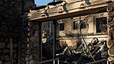 Hasi�i hasí ho�ící uhlíky u zni�ené budovy William D. Davies Memorial Building,...