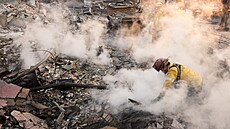 Hasi� odklízí kou�ící trosky na míst� stavby na Lake Avenue, kterou zni�il...