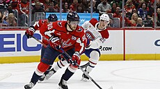 Pierre-Luc Dubois si kryje puk p�ed Jurajem Slafkovským.