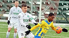 Karvinský obránce Michal Tomi se snaí dostat k míi, který si kryje opavský...