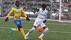 Karvinský zálo�ník Emmanuel Ayaosi si hlídá balon p�ed dobíhajícím opavským...