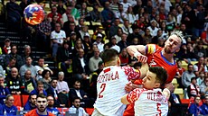 �eský házenká� Dominik Solák (vpravo naho�e) st�ílí p�es polské duo Damian...