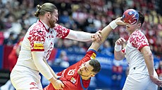 �eský házenká� Tomá� Babák (v �erveném) se sna�í vyst�elit na polskou bránu,...