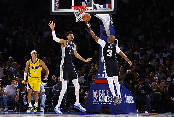 Chris Paul a Victor Wembanyama ze San Antonio Spurs bhem zápasu s Indiana...