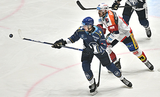 Kladenský Tomá� Vandas se natahuje pro puk p�ed pardubickým Milo�em Kelemenem.